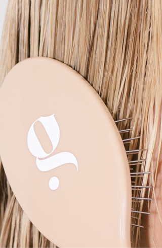 Glow Beauty Detangling Brush held in hand