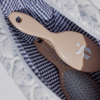 Glow Beauty Mini Detangling Brush clipped to bag