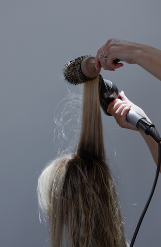 Model using Glow Beauty Round Brush for a blowout