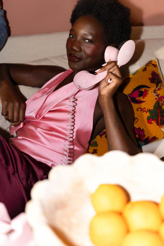 The Mini in pink, held to the ear like a phone